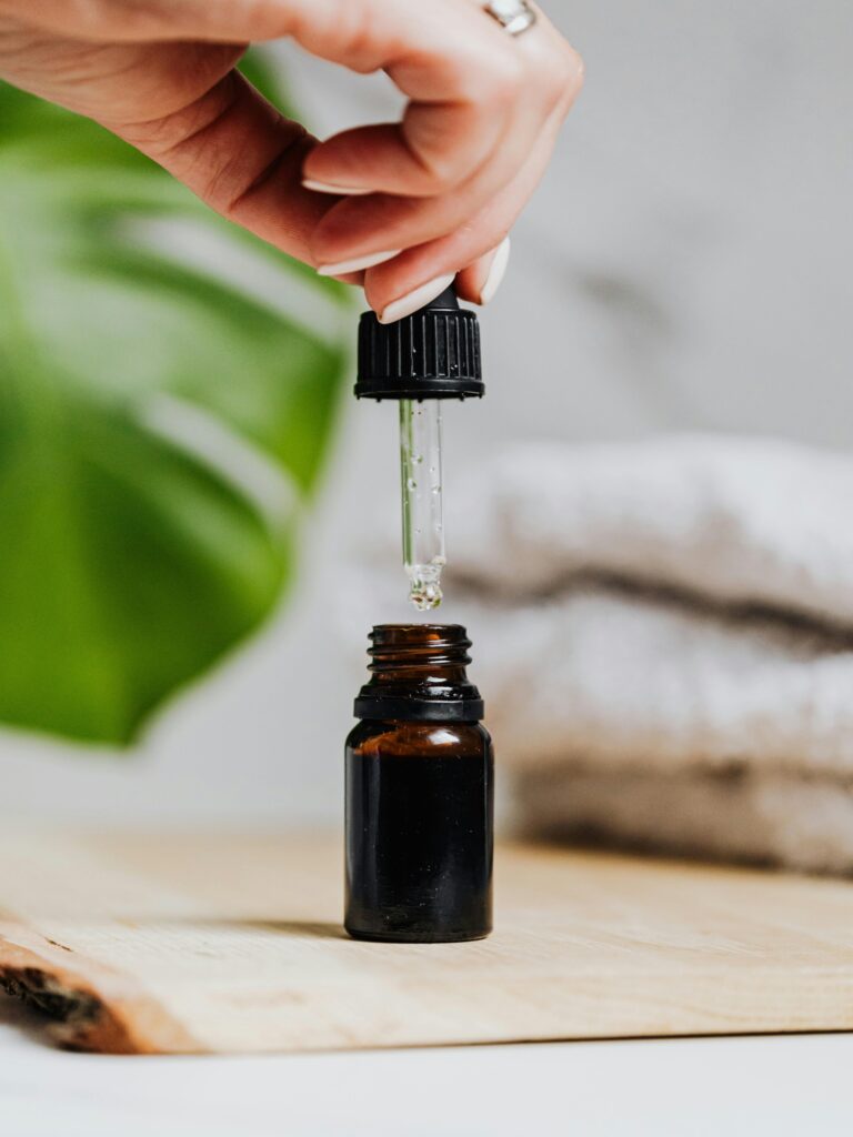 A person holding a bottle of essential oil.