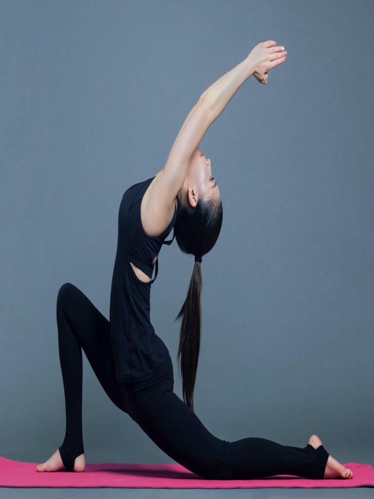 A woman practicing yoga on a pink mat