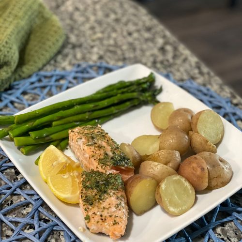 A plate with salmon, potatoes, and asparagus.