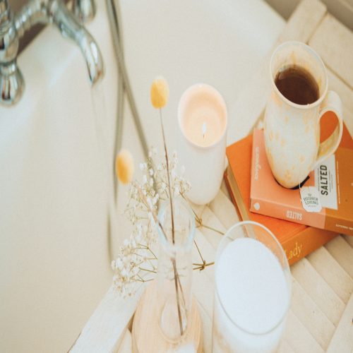 a cup of coffee and some books on a bathtub