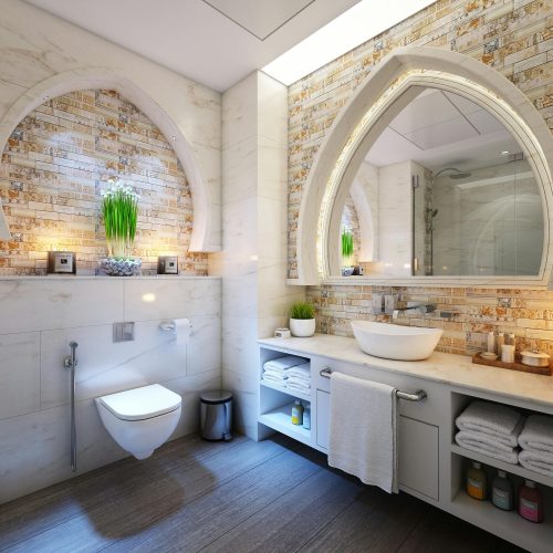 a bathroom with a toilet, sink, and mirror