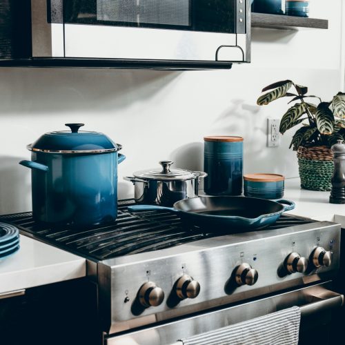 A vibrant stove top adorned with a collection of blue pots and pans.