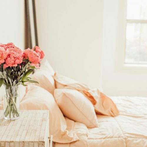 A beautiful vase filled with delicate pink flowers in a bedroom.