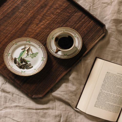 A cozy scene with a cup of coffee and a book on a bed.