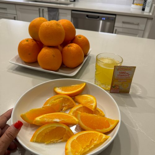 A person holding a bowl of juicy oranges on a kitchen counter, ready to enjoy a refreshing and healthy snack.