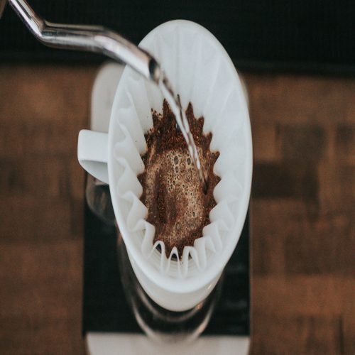 a close up of a coffee maker on a wooden table