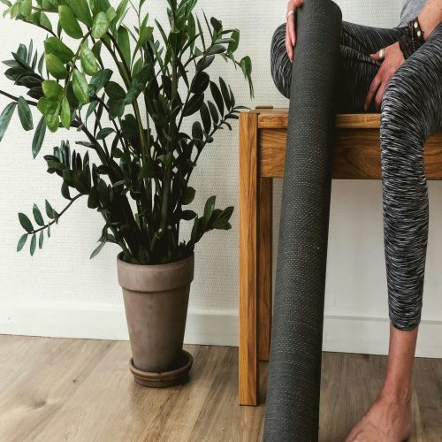 Female on bench with yoga mat.