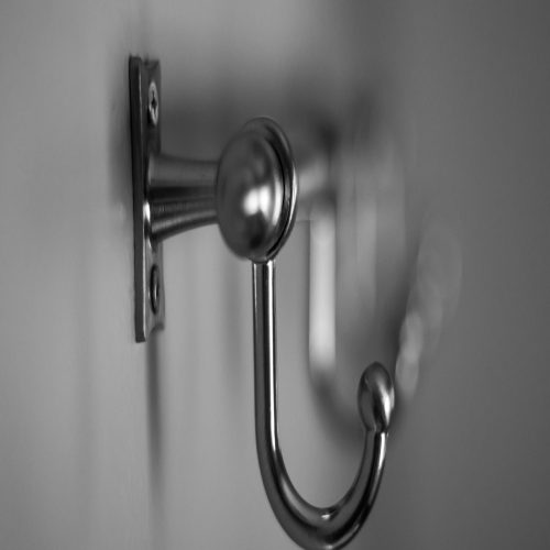 a black and white photo of a hook on a wall