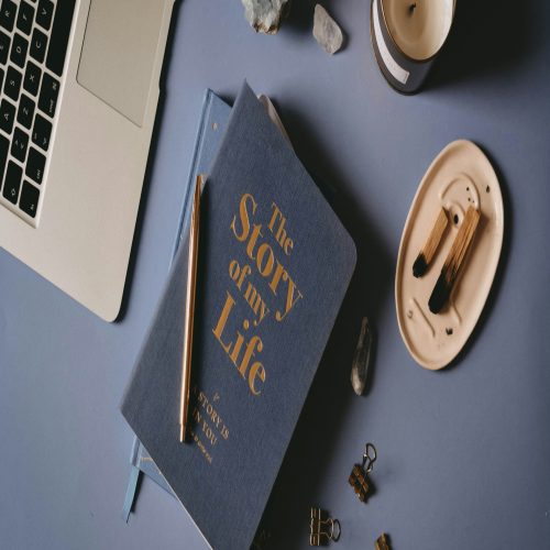 a book sitting on top of a table next to a laptop