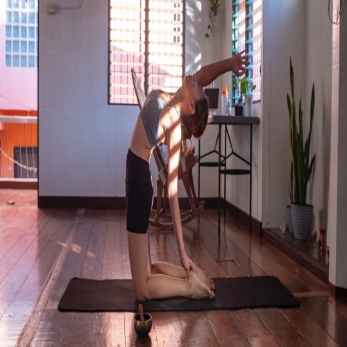 A serene woman gracefully practicing yoga in a sunlit room.