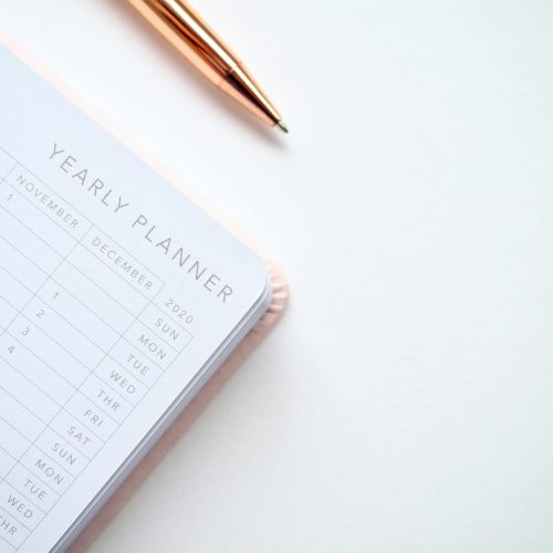 A planner with a pen on a white background.