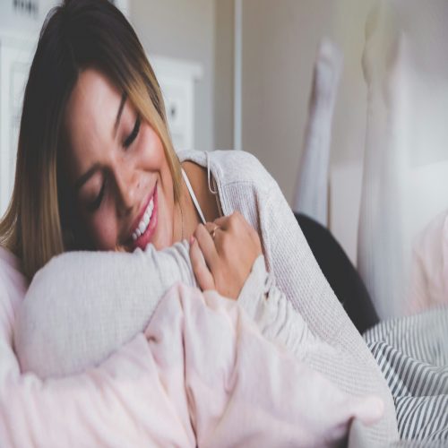 A smiling woman relaxing on a bed.